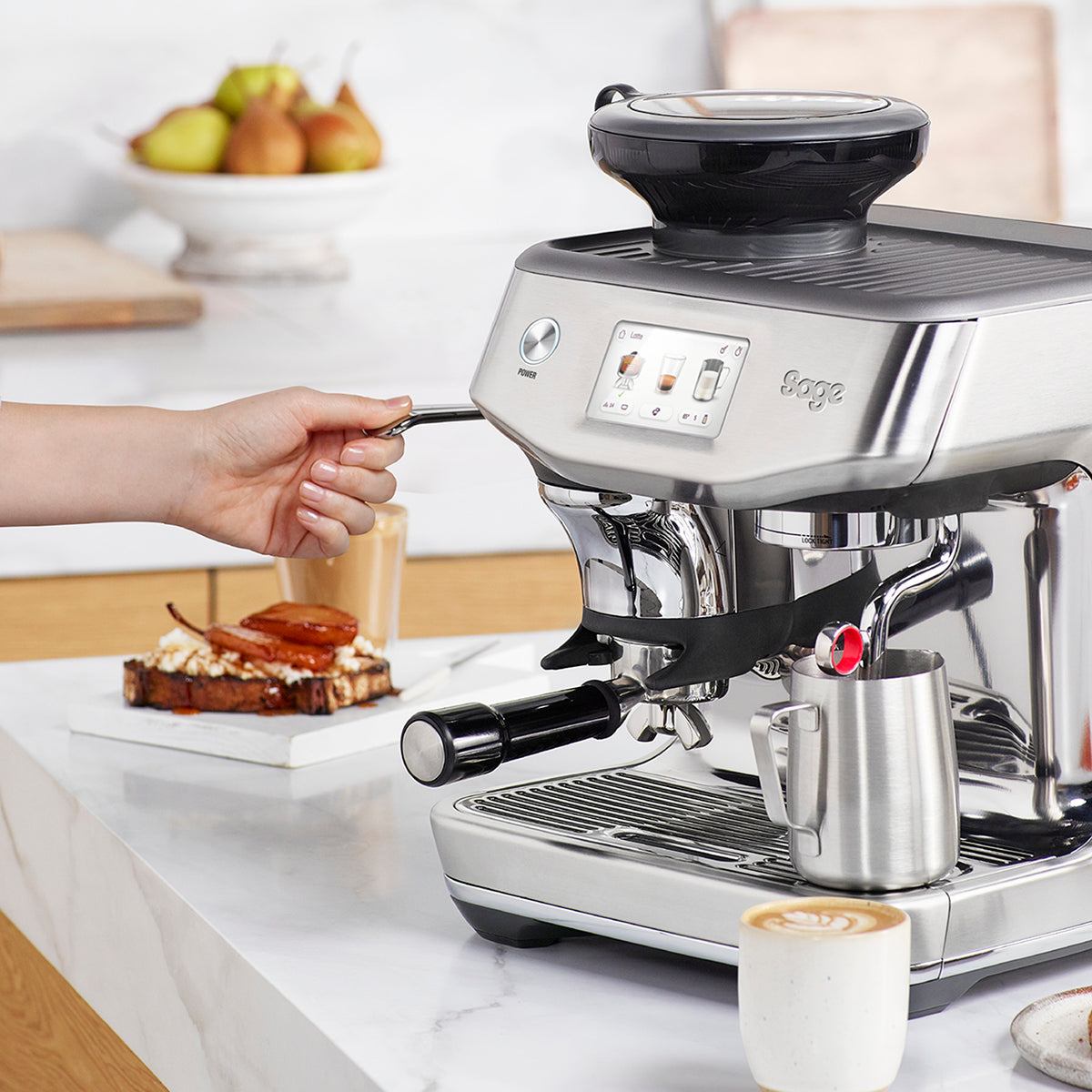 Pulling the Impress tamp lever on the Barista Touch Impress in brushed stainless steel, official Sage photography