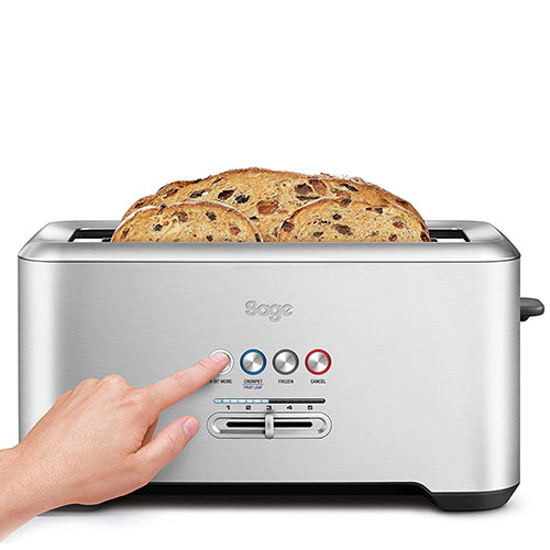 A hand pressing a button on Sage the A Bit More Toaster 4 Slice with a long fruit loaf slice in the slot, official view