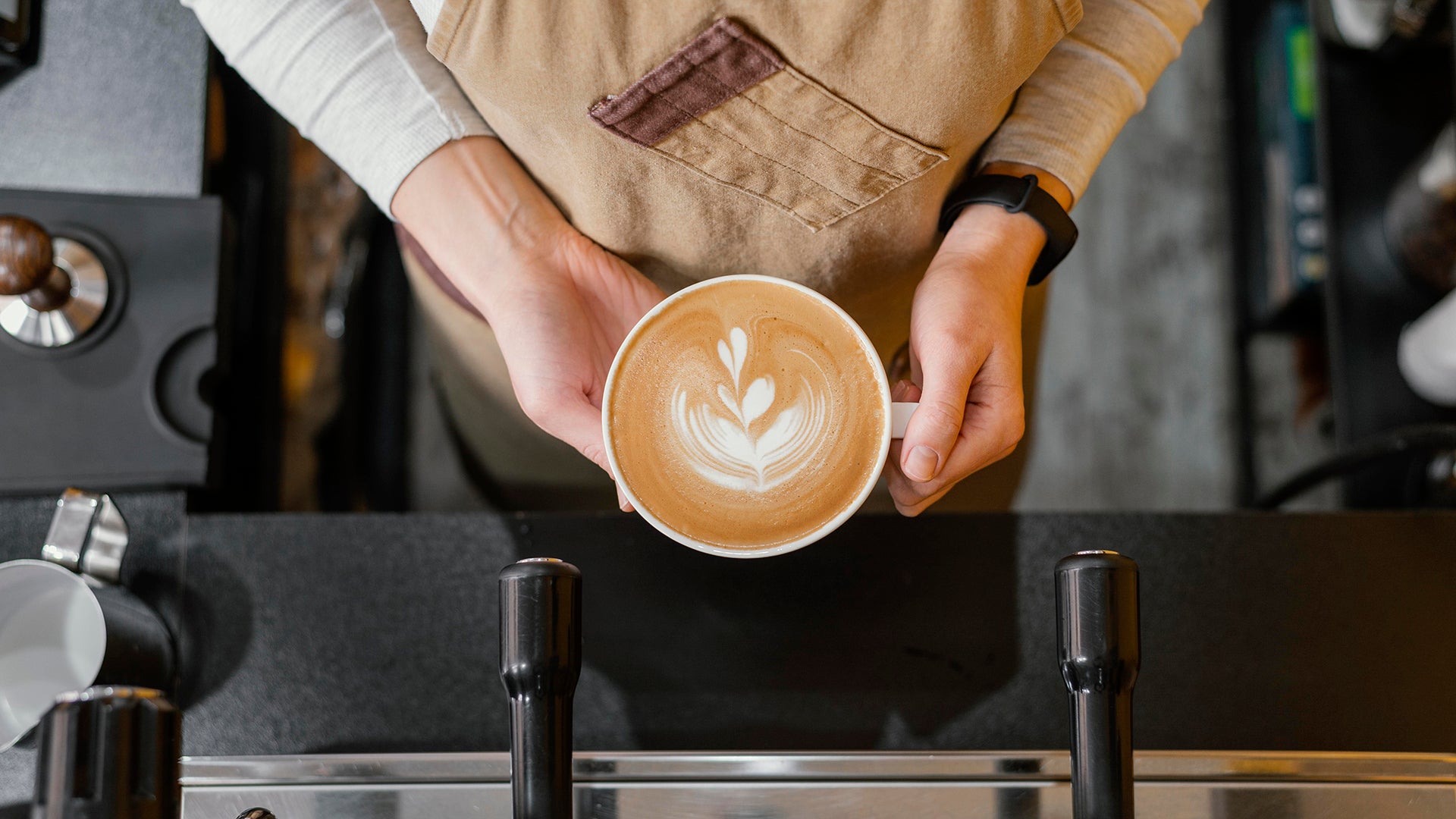 image of a barista holding a perfect cup of specialty coffee. Blog post title, "The ultimate tips to the perfect cup of specialty coffee."  Blog description 6 steps to produce the perfect cup of specialty coffee and the additional tips and tricks 