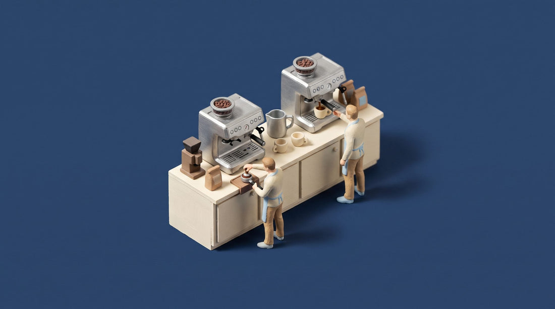 Miniature model of two near-identical home espresso machines with built-in grinders on a kitchen counter, one figure tamping and one pulling a shot