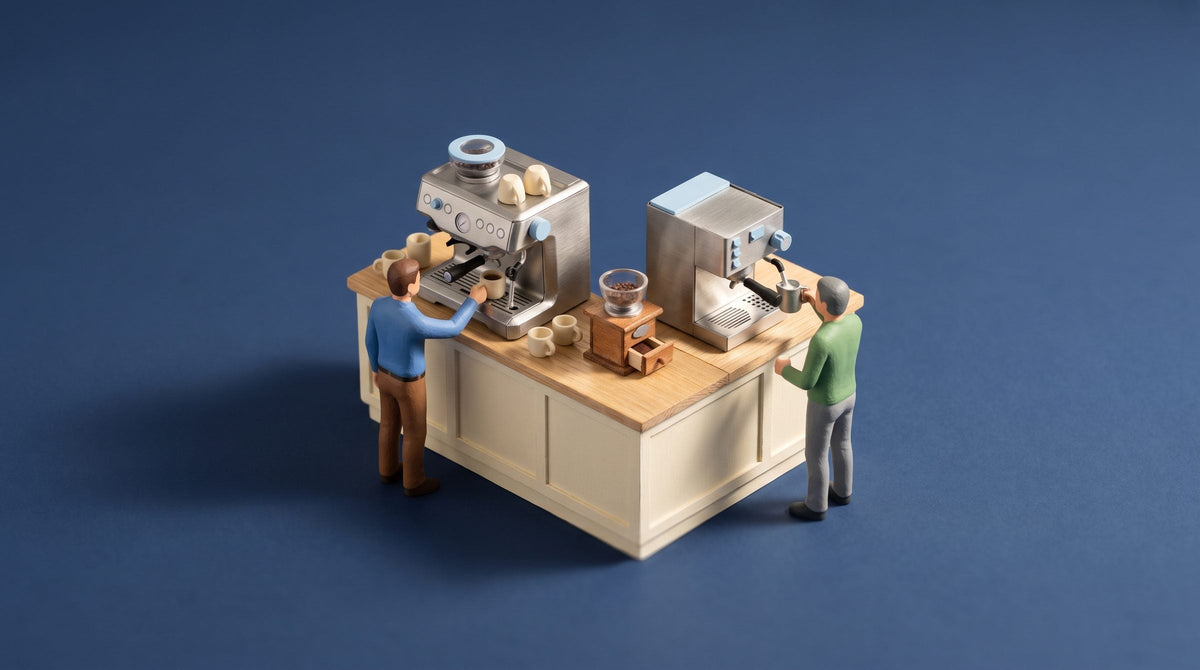 Miniature model of a kitchen island with a larger and a more compact single-group espresso machine, one figure pulling a shot and one steaming milk