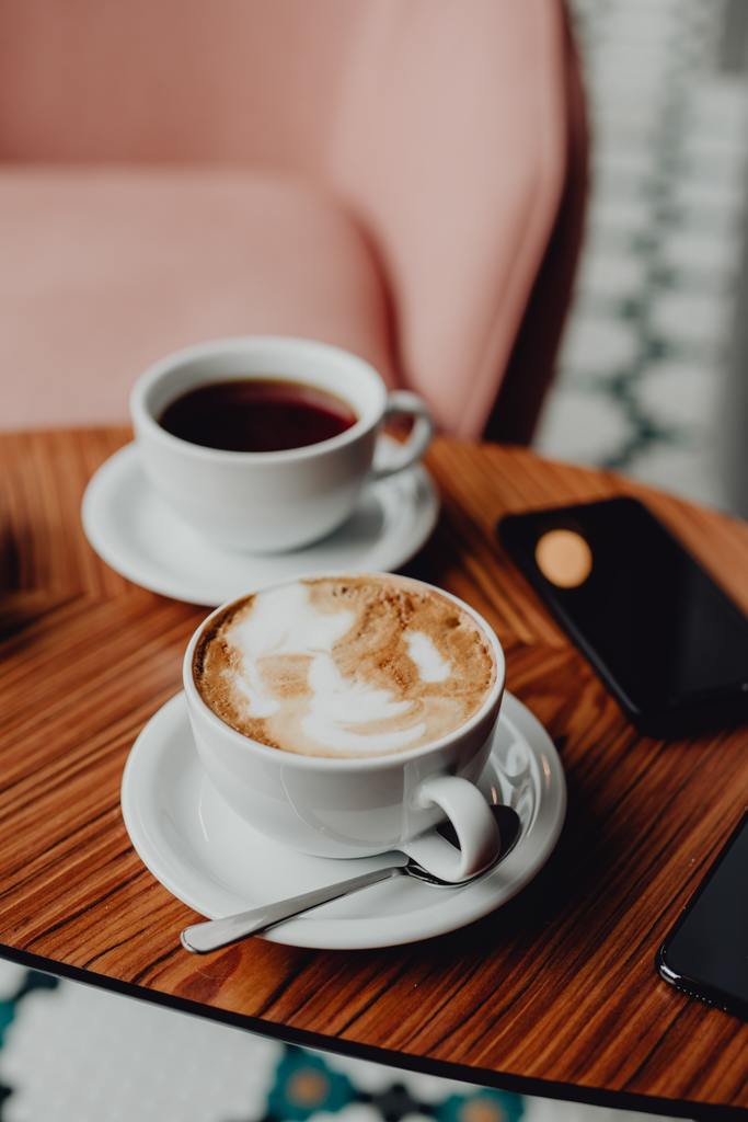 image: Two cups of coffee one black and one with milk . Blog title: Does milk have an effect on the experience of drinking specialty coffee?